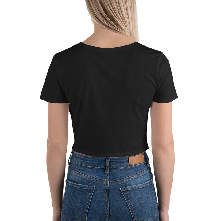 Rearview of young woman modeling a black 'Happy Friendship Day' crop top against a brick background, highlighting its slim fit and stylish design