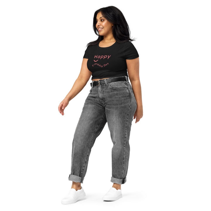 Woman in a black 'Happy Friendship Day' crop top paired with gray jeans, showcasing a comfortable yet chic look.